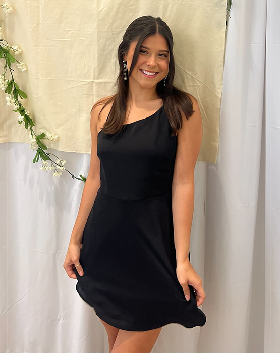 woman standing in black dress smiling 