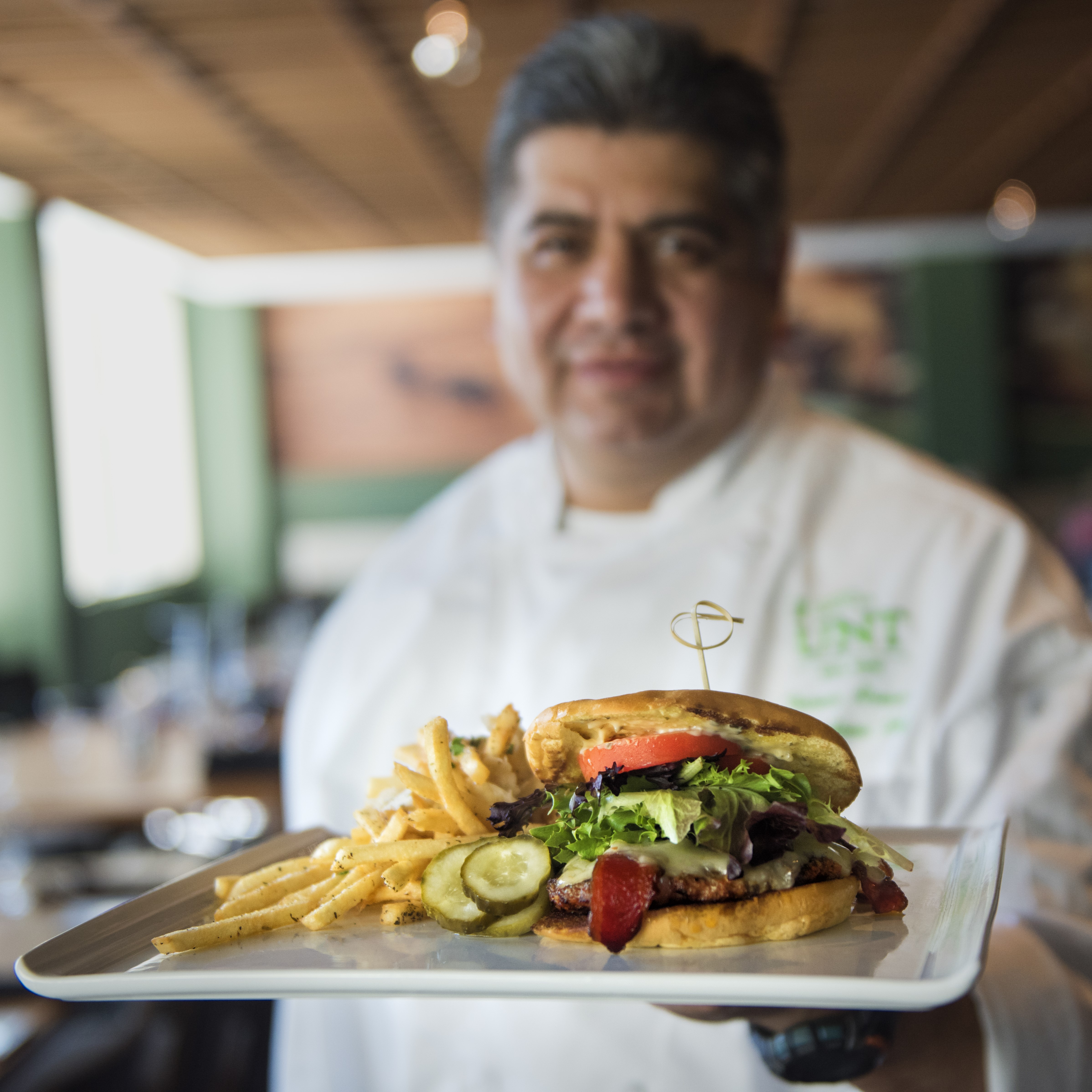 UNT chef holding a burger