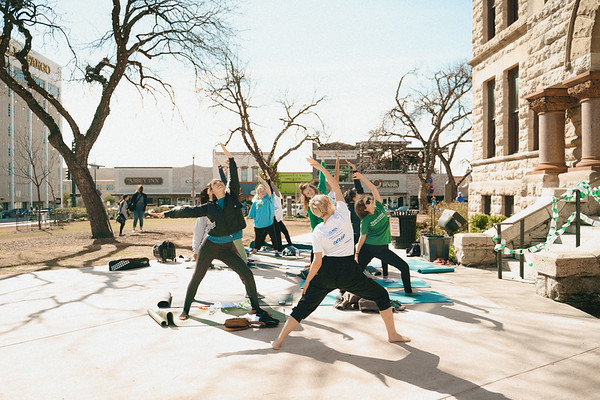 group doing yoga on the Denton square