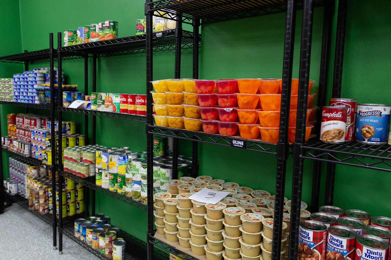 An interior photo of the food pantry with donations stacked up on the shelves.