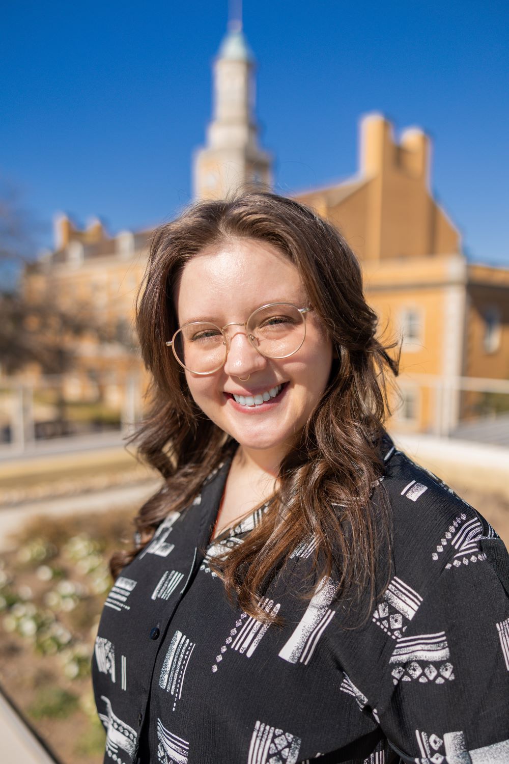 a person smiling in front of building