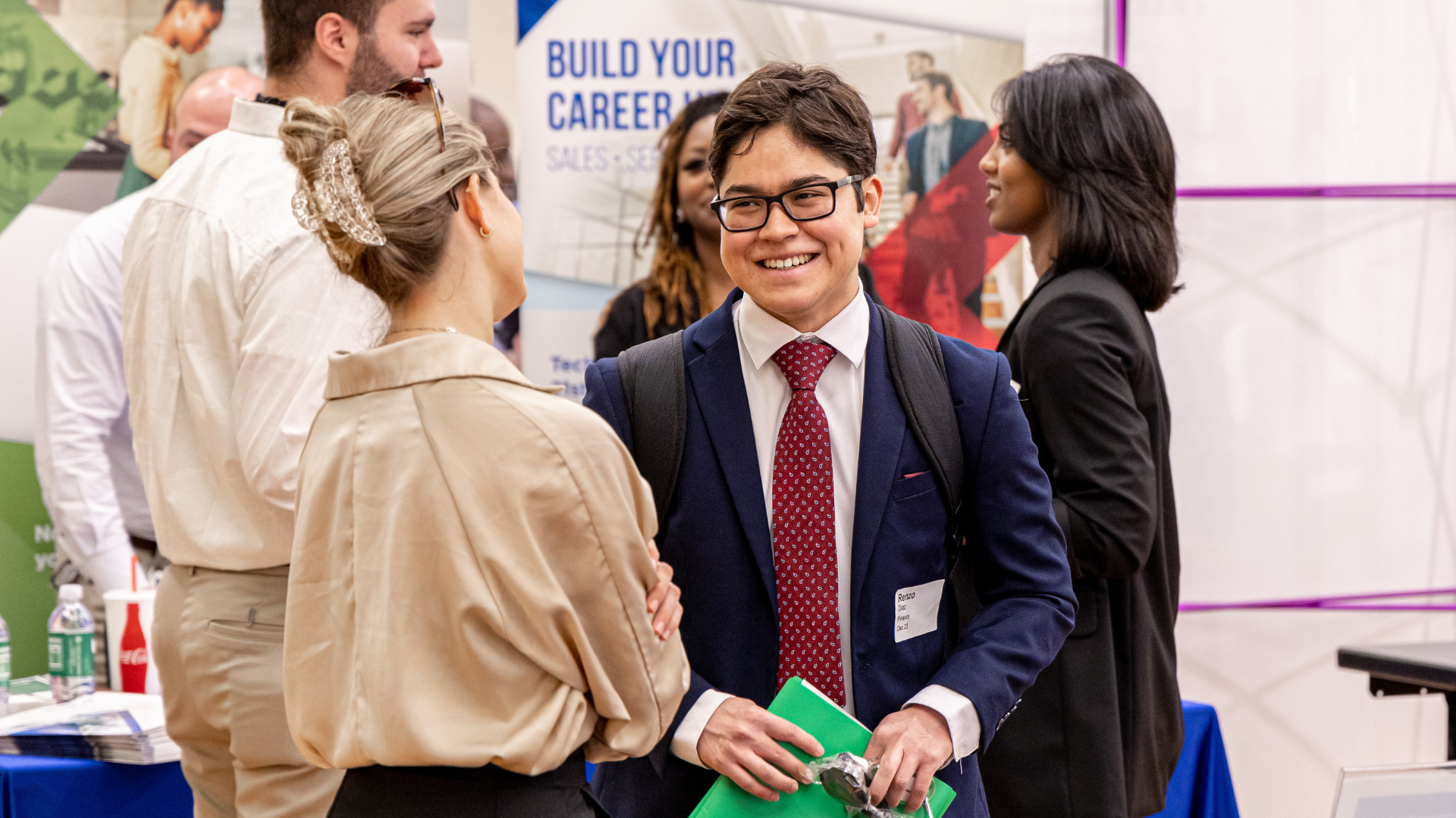 Student smiling while wearing a blue blazer at a job fair