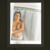 light box framed photograph of of a woman in her underwear standing