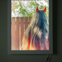 light box framed photograph of a long long haired figure
