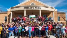 Greek students in front of center for fraternity and sorority life building