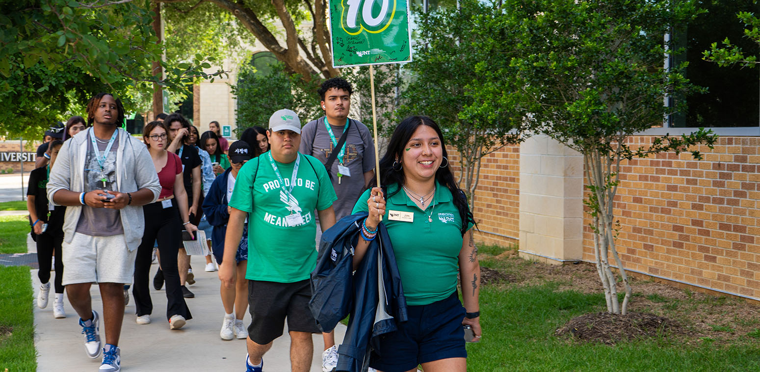 Orientation leader walking a group across campus