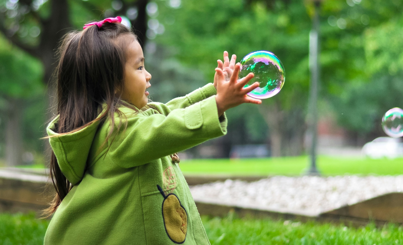 Young girl playing with bubbles