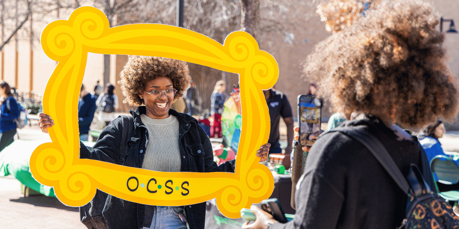 student holding yellow frame that says ocss