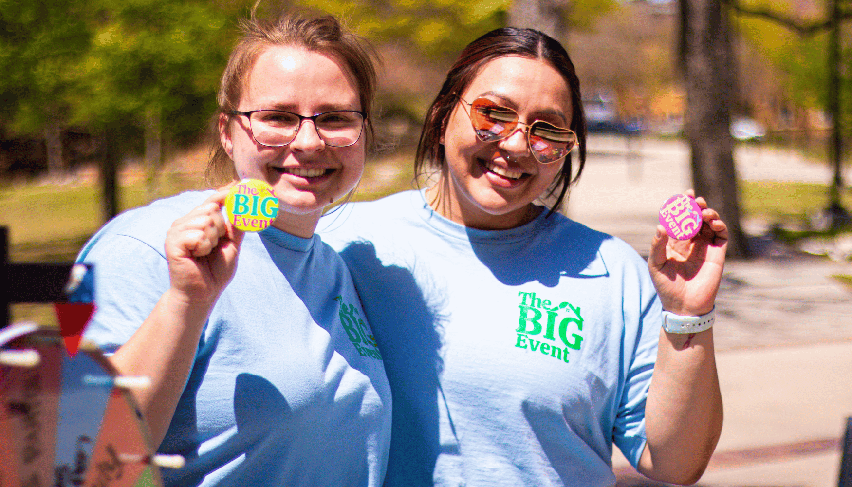 two people holding big event buttons