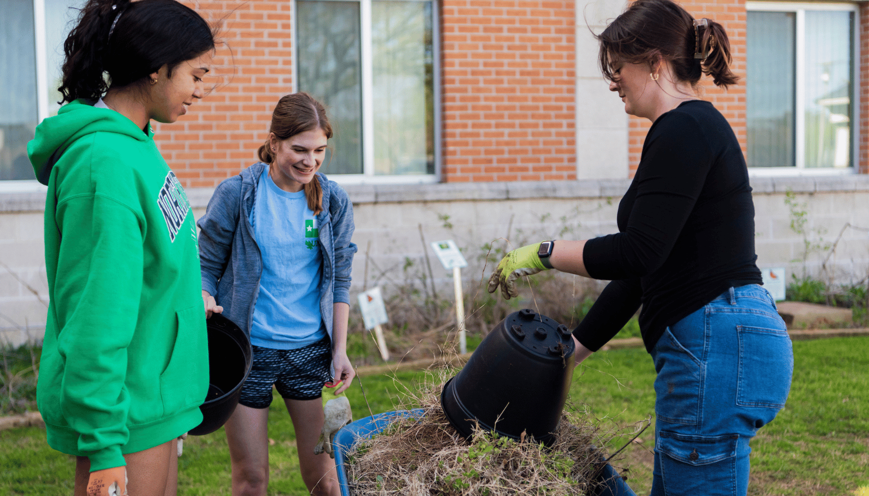 three people around soil and a barrel
