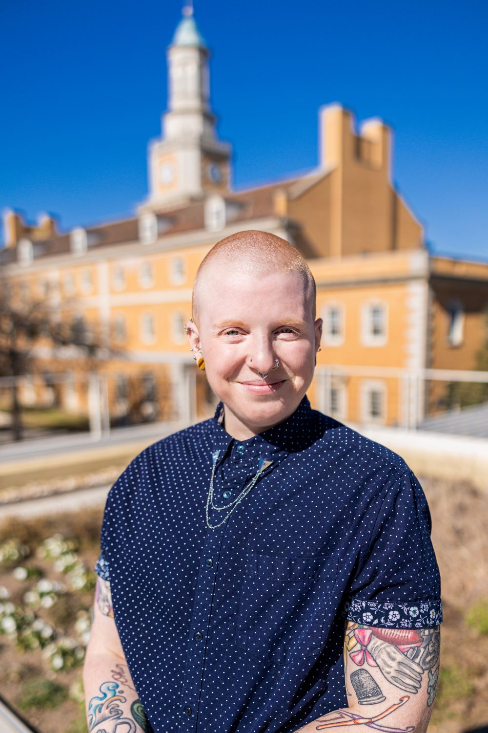 A person in a dark blue button up shirt smiling