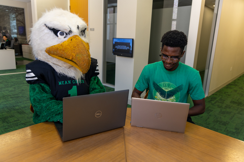 Photo of student on a laptop with Scrappy on a laptop.