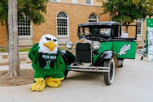 Scrappy stands outside the UNT Admin building with our custom UNT classic.