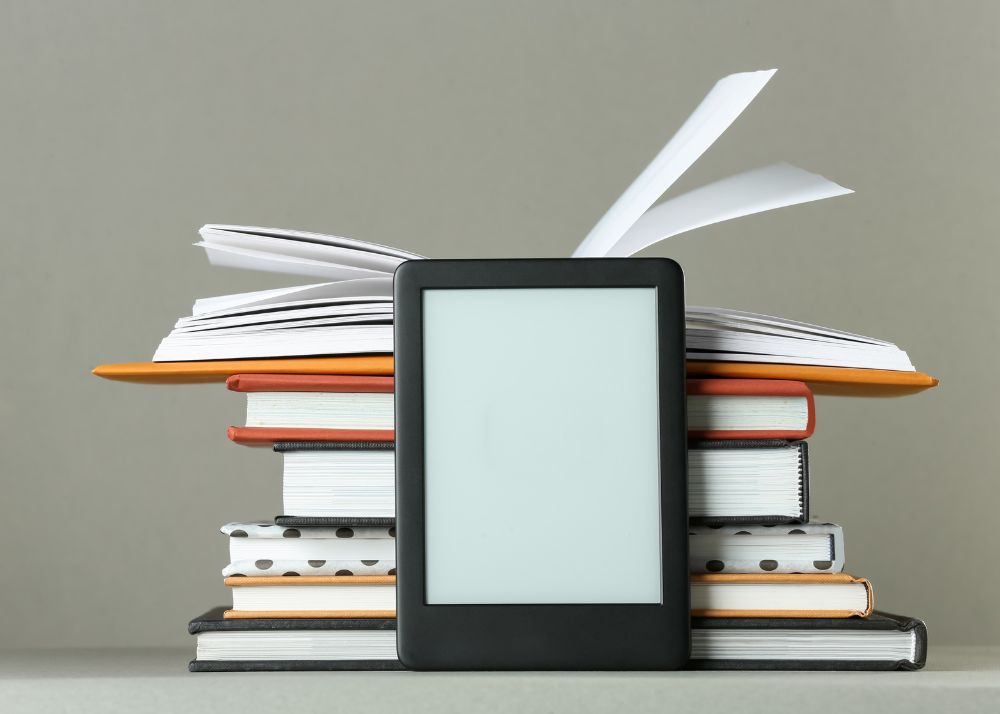 Photo of a stack of books and an eReader Device