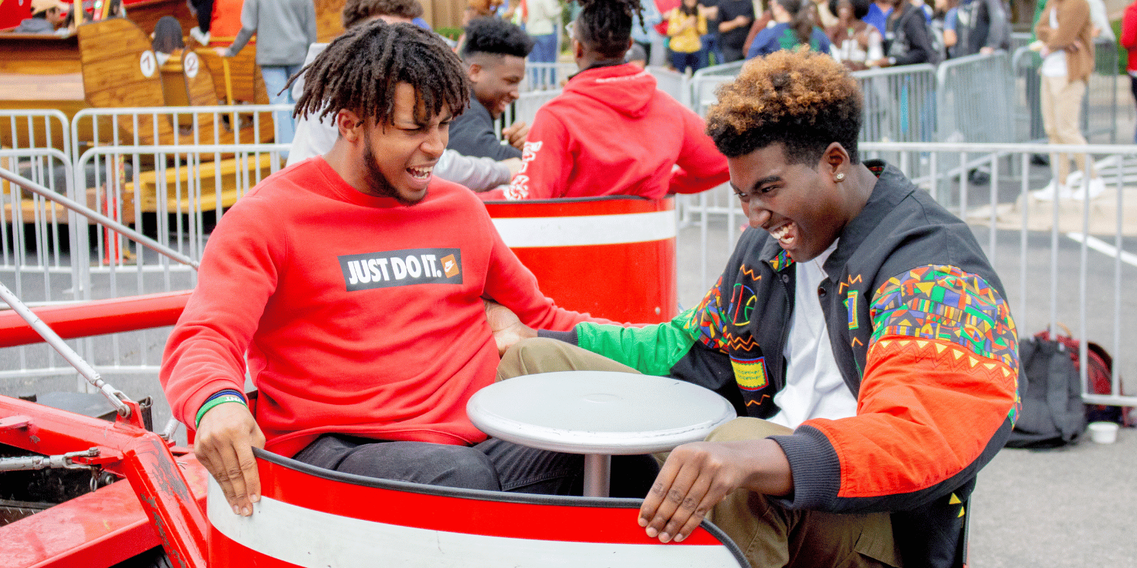 two students riding carnival ride laughing