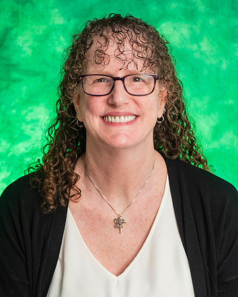 brown curly hair, glasses, green background