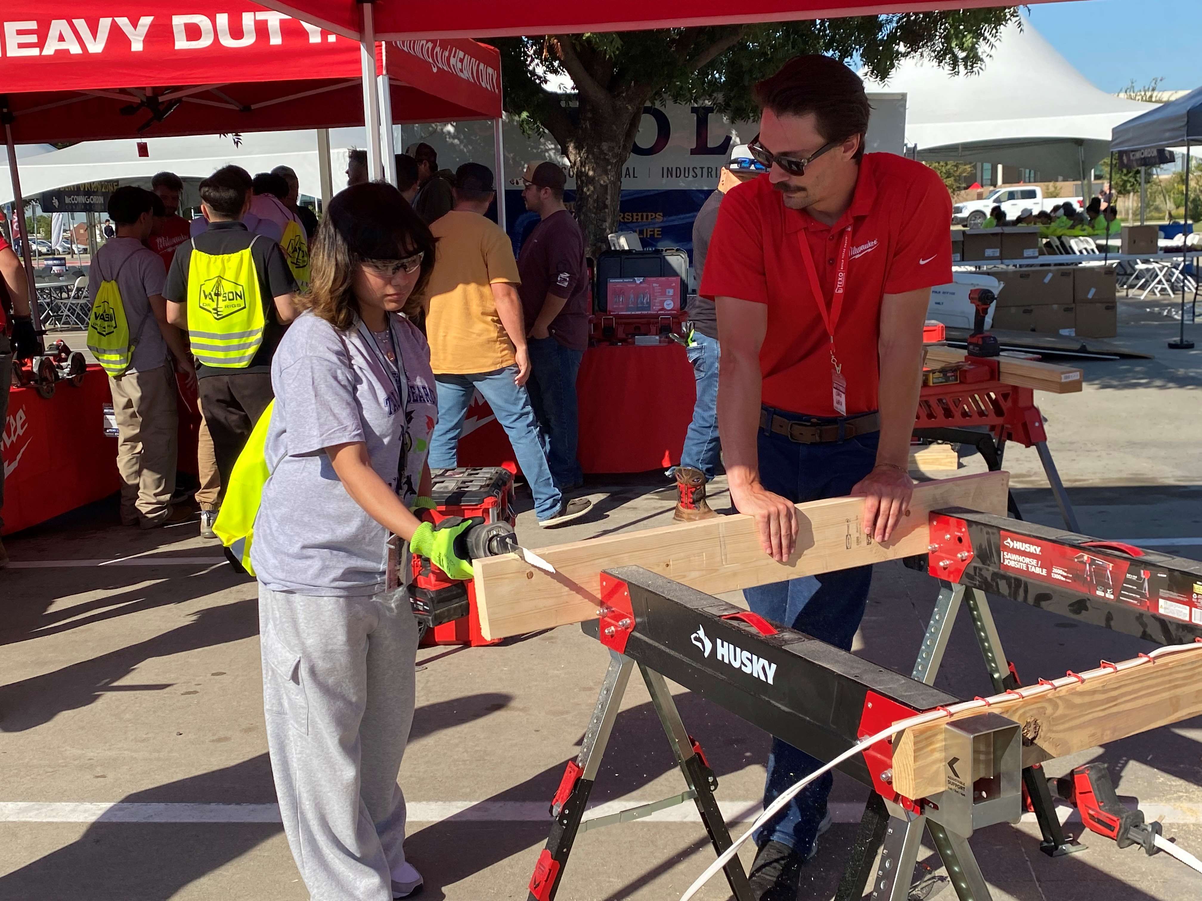 student sawing wood