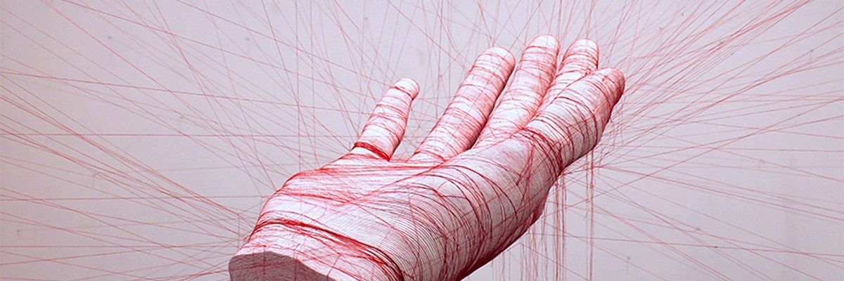 entanglement exhibition large hand sculpture held my red strings