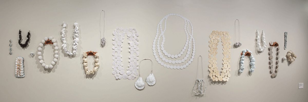 image of necklaces hanging on art gallery wall